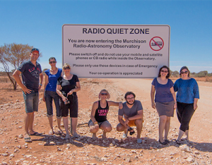 ICRAR Outreach staff and collaborators at the 'Radio Quiet' sign on the road near the MRO.