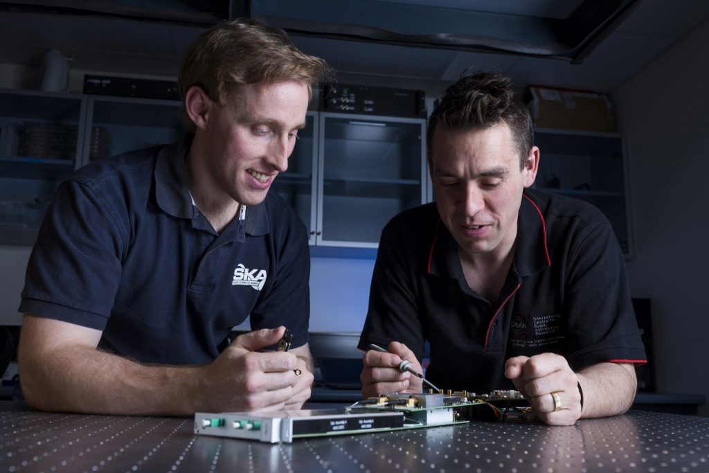 Sascha Schediwy and David Gozzard with components of their SKA-mid phase synchronisation system Transmitter Module. Credit: ICRAR.