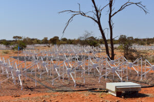 The triangular antennas of the MWA telescope, arranged in square 'tiles', on the red dirt of the Murchison region.